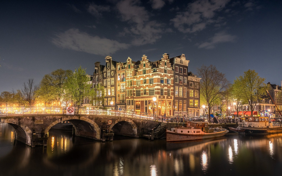 Beleuchtetes Geb&auml;ude mit Fluss und Schiffen