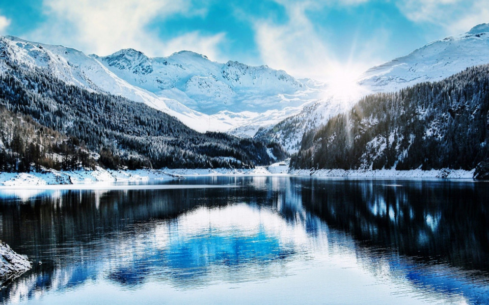 Berge und W&auml;lder mit Schnee und See im Winter
