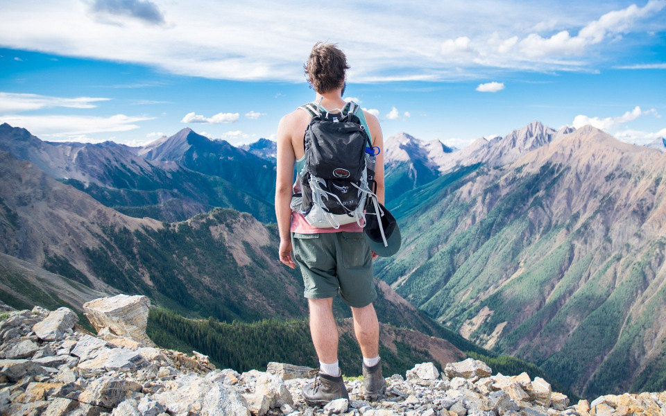 Mann steht auf einem Gipfel 