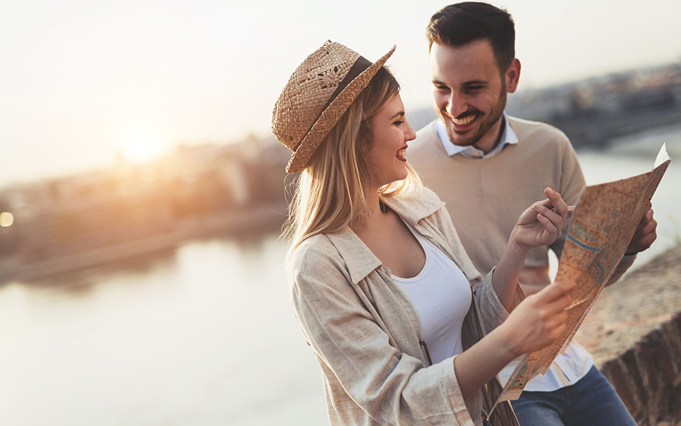 Ein Paar genie&szlig;t einen Landausflug bei einer Kreuzfahrt und betrachtet gemeinsam eine Karte.