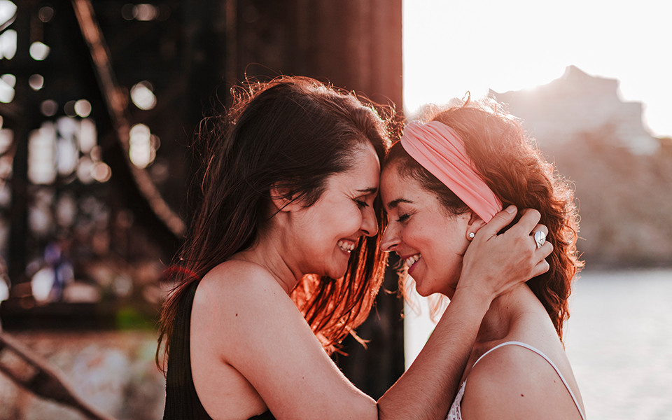 Zwei glückliche Frauen lachen sich an in Sitges