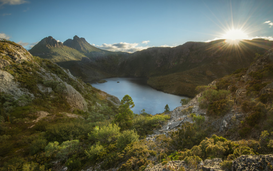 Sonnenaufgang &uuml;ber dem Cradle Mountain und Lake St. Clair, umgeben von wilden, h&uuml;geligen Landschaften und W&auml;ldern.